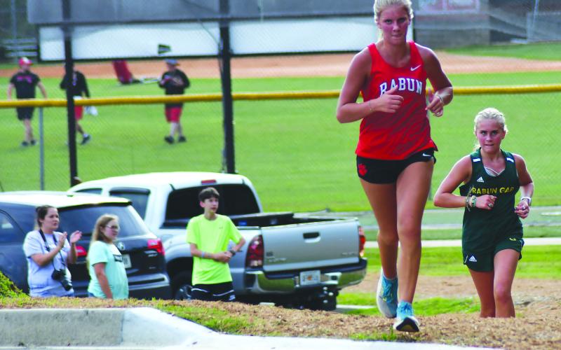 Enoch Autry/The Clayton Tribune. RCHS’s Molly Jo Wright and Rabun Gap’s Bailey Brackett head toward the stadium at the unveiling of the new course Aug. 18. Wright claimed second and Brackett took third.