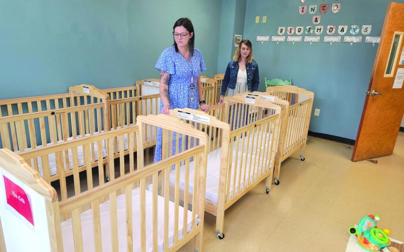 Enoch Autry/The Clayton Tribune. Assistant Director Hannah Cannon and Director Tiffany Prescott check the cribs in The Creative Learning Center’s infant program, set to open Aug. 5.