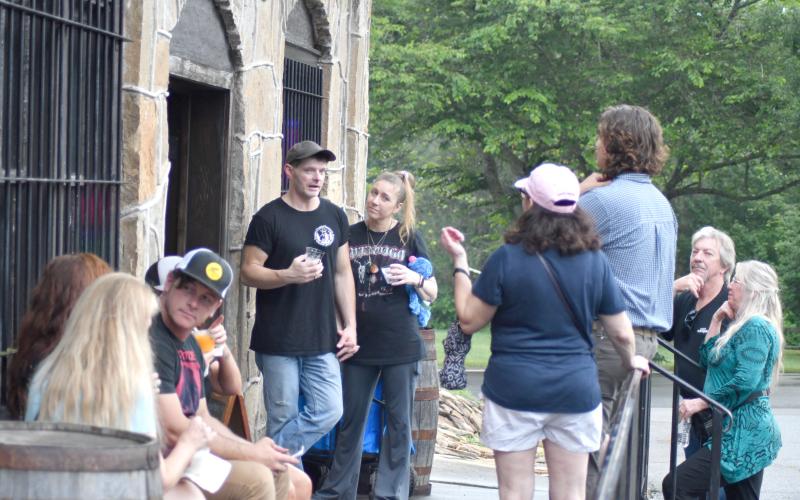 Enoch Autry/The Clayton Tribune.  Matt Delph, one of the World UFO Conference speakers, talks with people outside R.M. Rose Distillery on June 28 in Dillard. Below: Those in attendance even donned springy antenna to salute the visitors from afar.
